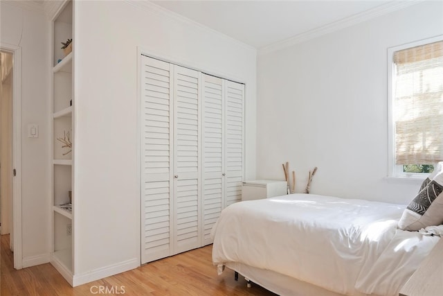 bedroom featuring light wood-type flooring, a closet, multiple windows, and crown molding