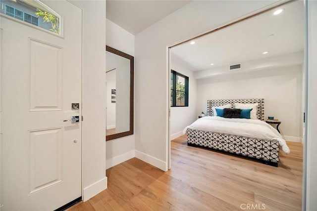 bedroom featuring light wood-style floors, recessed lighting, visible vents, and baseboards