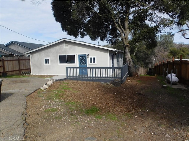14370 Ridge Rd, Clearlake, CA 95422 - rear view of property featuring stucco siding, fence, and a wooden deck