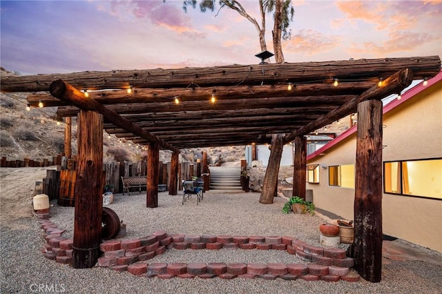 patio terrace at dusk featuring fence