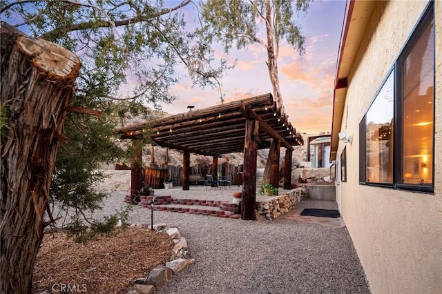 patio terrace at dusk with a fenced backyard