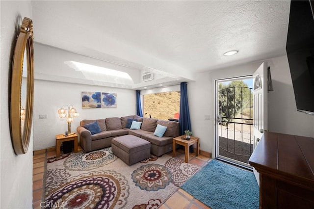 living area with visible vents and a textured ceiling