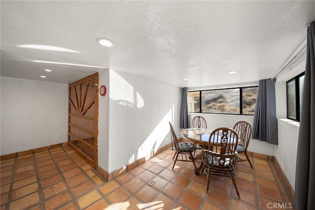 dining space featuring recessed lighting, a textured ceiling, and baseboards