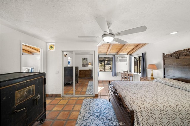 bedroom with a textured ceiling, dark tile patterned floors, a closet, and vaulted ceiling with beams