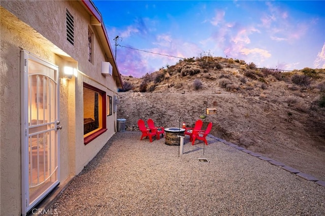 yard at dusk featuring an outdoor fire pit and a patio area