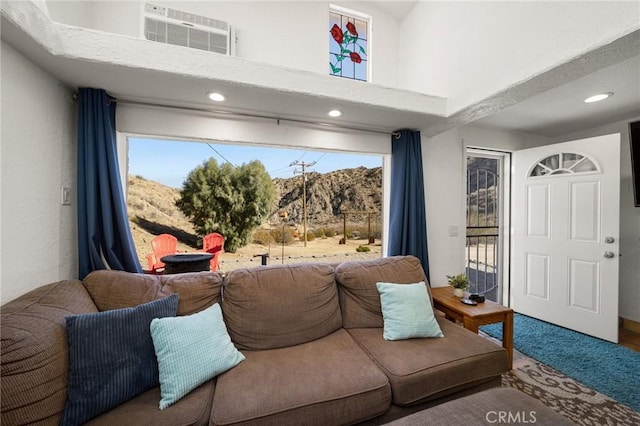 carpeted living area with a towering ceiling, visible vents, and a wealth of natural light