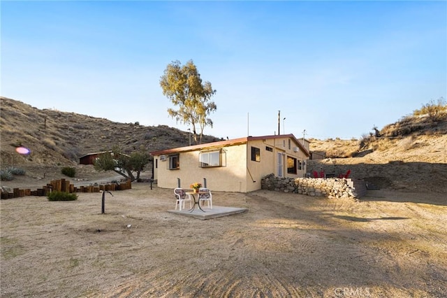 rear view of property featuring a patio area, a mountain view, and stucco siding