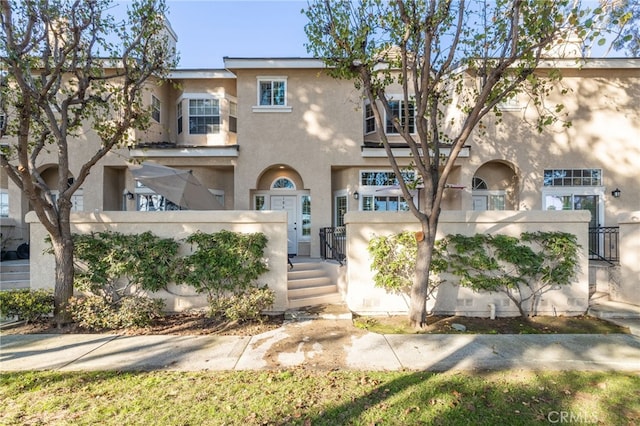 view of front of home with a fenced front yard, a gate, and stucco siding