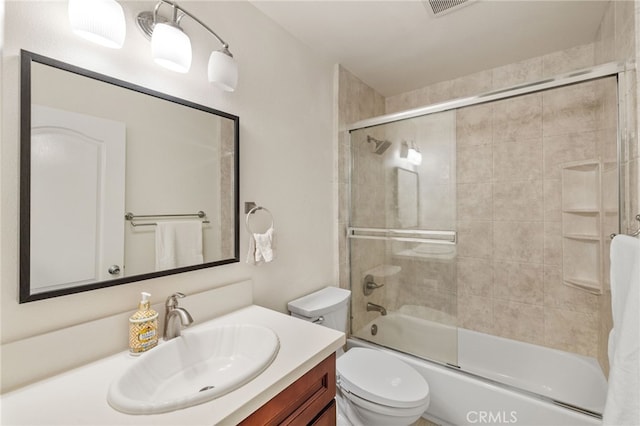 bathroom featuring visible vents, vanity, toilet, and bath / shower combo with glass door