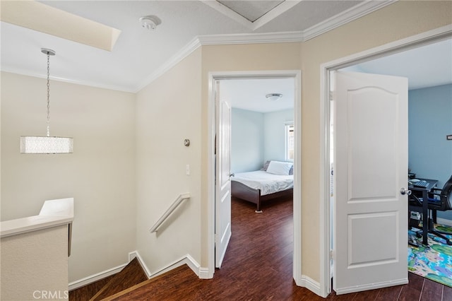 hallway featuring baseboards, dark wood finished floors, an upstairs landing, and crown molding