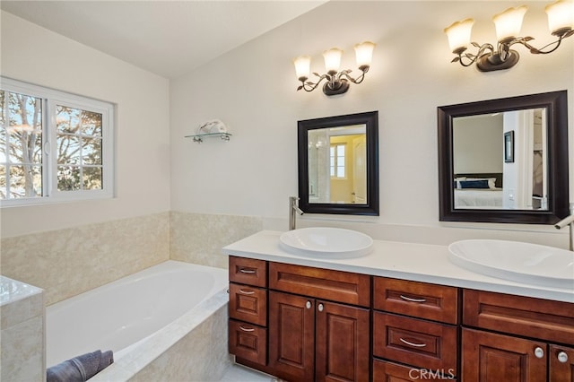 ensuite bathroom featuring double vanity, ensuite bath, a sink, and a bath