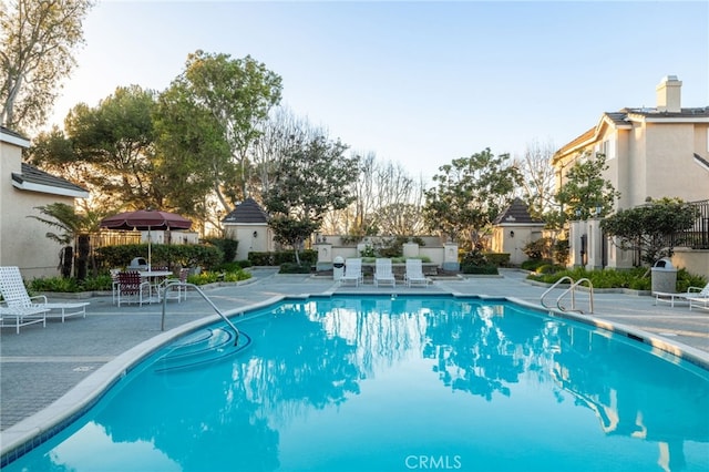 community pool featuring a patio and fence