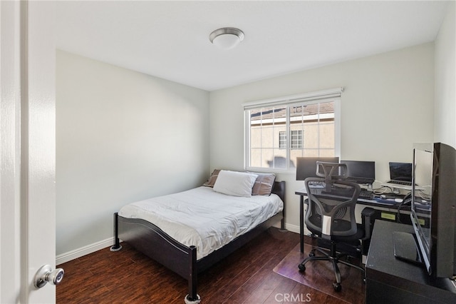 bedroom with dark wood-style flooring and baseboards