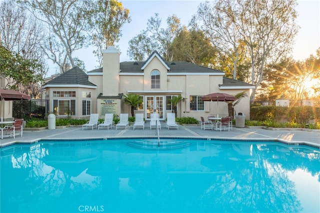 pool with a patio area and fence