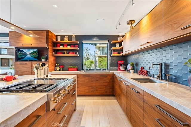 kitchen featuring brown cabinets, stainless steel gas cooktop, open shelves, light countertops, and modern cabinets