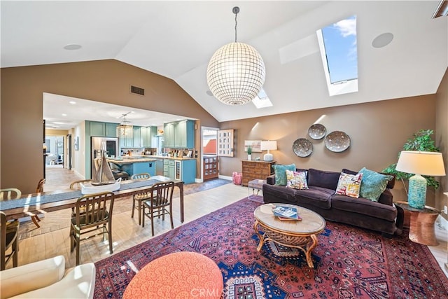 living area with lofted ceiling with skylight, baseboards, visible vents, and light wood-style floors