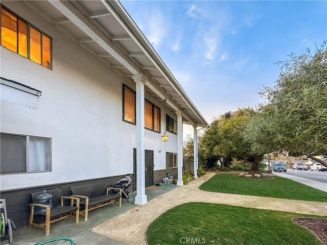 view of property exterior featuring a lawn and stucco siding