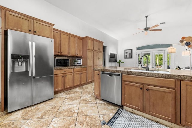 kitchen featuring appliances with stainless steel finishes, brown cabinetry, and a sink