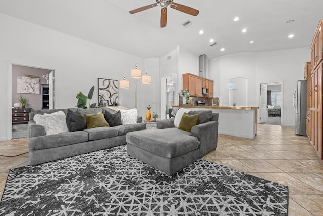 living area featuring light tile patterned floors, high vaulted ceiling, arched walkways, recessed lighting, and a ceiling fan