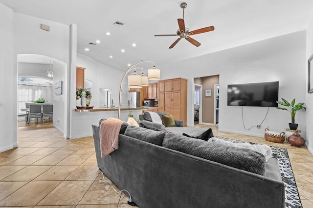 living room featuring arched walkways, light tile patterned floors, visible vents, and a ceiling fan