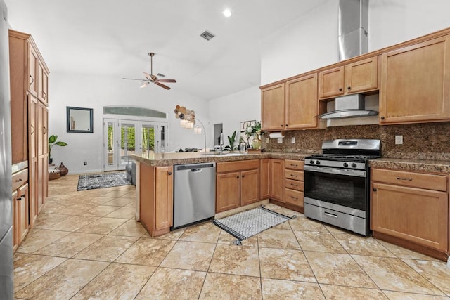 kitchen with visible vents, dark countertops, wall chimney exhaust hood, stainless steel appliances, and french doors