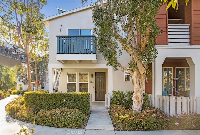 view of front facade featuring a balcony and stucco siding