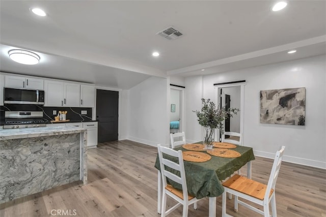 kitchen featuring recessed lighting, visible vents, range with gas stovetop, light wood finished floors, and stainless steel microwave