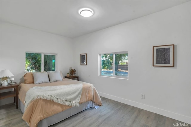 bedroom with baseboards and wood finished floors