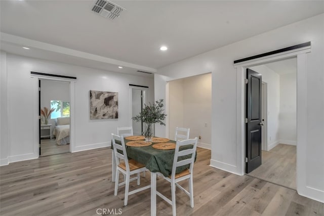 dining room featuring light wood-style floors, recessed lighting, visible vents, and baseboards