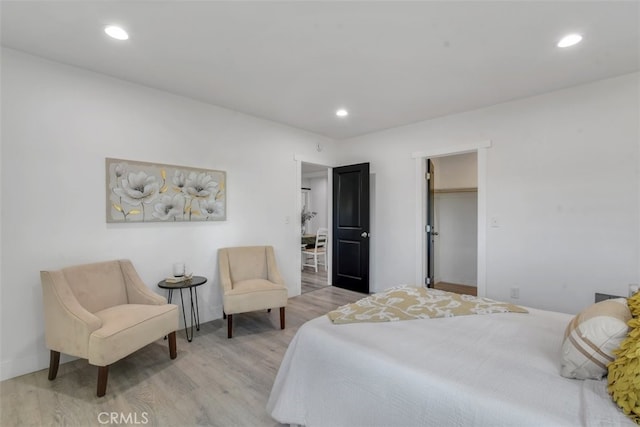 bedroom featuring recessed lighting, a spacious closet, and wood finished floors