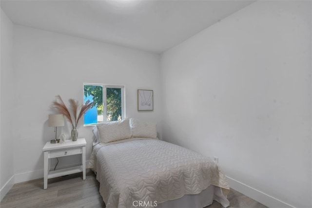 bedroom featuring baseboards and light wood-style floors