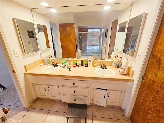 full bathroom featuring double vanity, tile patterned flooring, and a sink