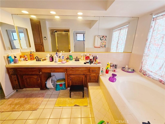 full bathroom featuring tile patterned flooring, a sink, a shower stall, a bath, and double vanity