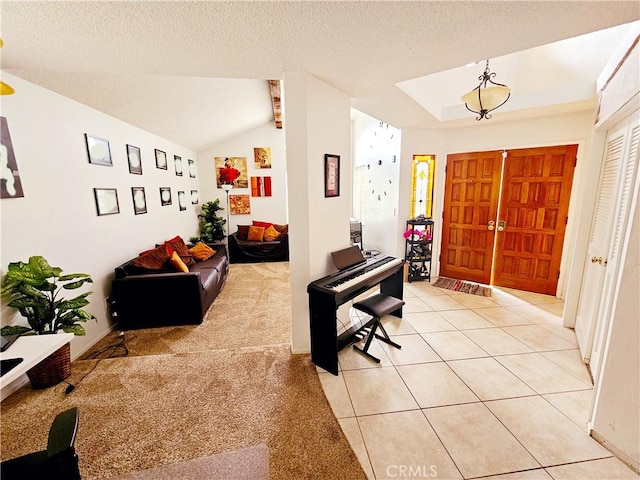 foyer with light colored carpet, vaulted ceiling, a textured ceiling, and light tile patterned flooring