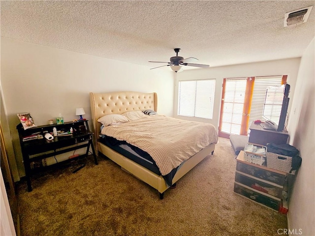 bedroom featuring carpet, a textured ceiling, visible vents, and a ceiling fan