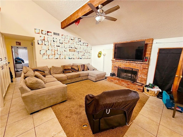 living room featuring light tile patterned floors, ceiling fan, a textured ceiling, a fireplace, and beamed ceiling