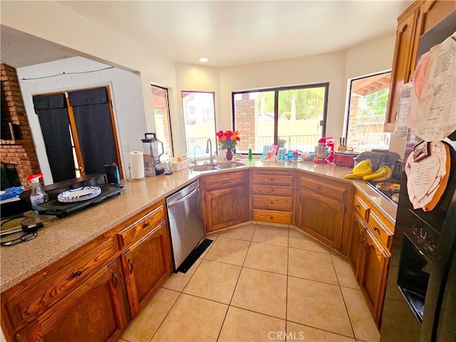 kitchen featuring brown cabinets, light countertops, dishwasher, and a sink