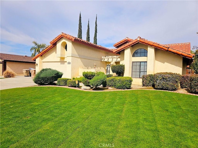 mediterranean / spanish home with stucco siding, concrete driveway, an attached garage, a front yard, and a tiled roof