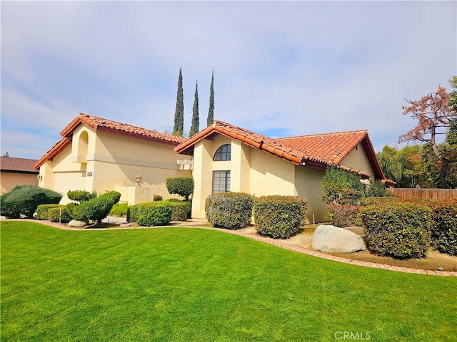 exterior space featuring fence, a yard, a tiled roof, and stucco siding