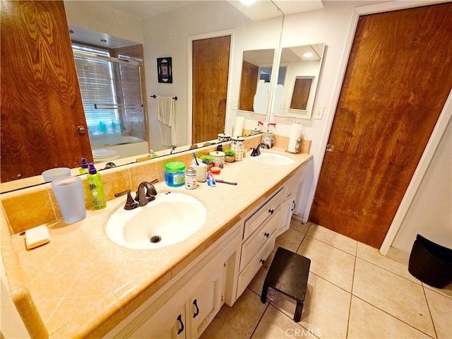 full bath featuring double vanity, tile patterned flooring, and a sink