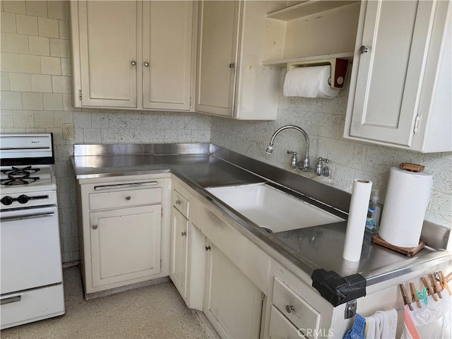 kitchen featuring a sink, stainless steel countertops, tasteful backsplash, and gas range gas stove