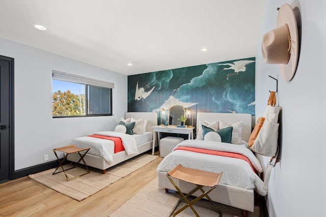 bedroom featuring an accent wall, baseboards, wood finished floors, and recessed lighting