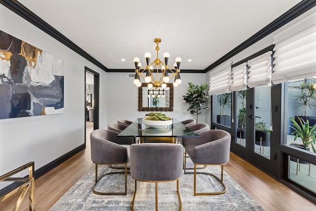 dining space featuring baseboards, an inviting chandelier, crown molding, french doors, and light wood-type flooring