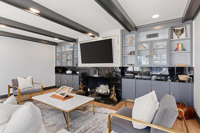 living room with light wood-type flooring, beam ceiling, visible vents, and recessed lighting