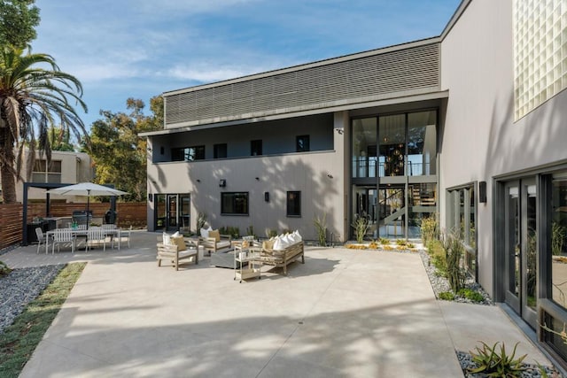 back of property with stairway, outdoor lounge area, a patio, and outdoor dining space