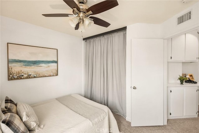 bedroom featuring a ceiling fan, light colored carpet, and visible vents