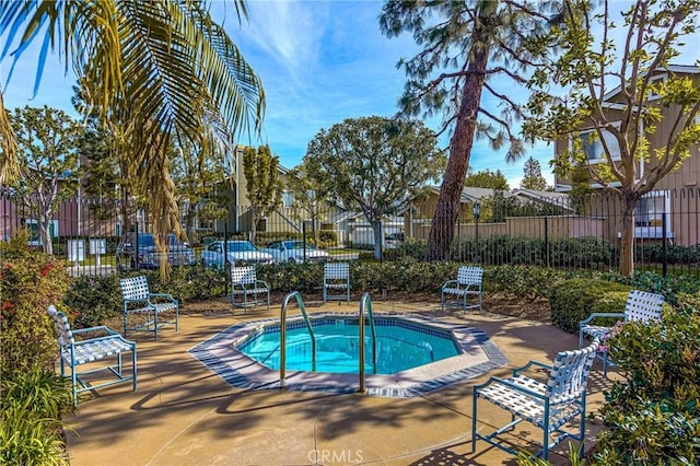 view of swimming pool featuring a patio area, fence, and a community hot tub