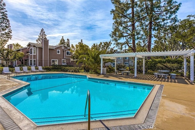 community pool with a patio area and a pergola