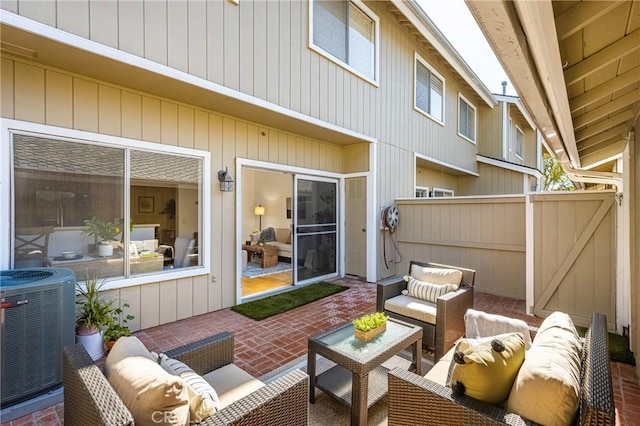 view of patio with outdoor lounge area, fence, and central AC unit