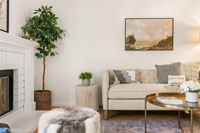 living area with a fireplace, baseboards, and dark wood finished floors